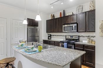 a kitchen with granite counter tops and stainless steel appliances